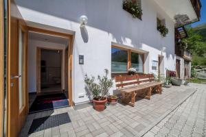 a patio with a wooden bench and potted plants at Ferienwohnung Haus Fliri in Curon Venosta