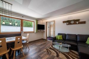 a living room with a couch and a table at Ferienwohnung Haus Fliri in Curon Venosta