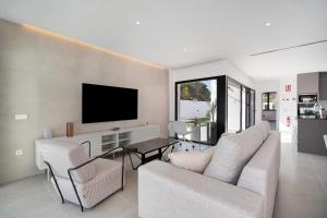 a living room with a couch and chairs and a tv at Andrea Sea Villa in Novo Sancti Petri