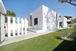 a white house with a green lawn at Andrea Sea Villa in Novo Sancti Petri