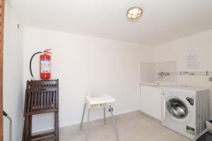 a laundry room with a washing machine and a stool at San Teodoro Villa Nina Costa Caddu in San Teodoro