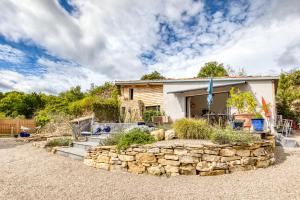 a house with a stone wall in front of it at Le Mas de Coeur in Bédarieux