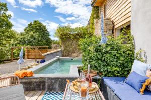 a patio with a plunge pool and a table with a table at Le Mas de Coeur in Bédarieux
