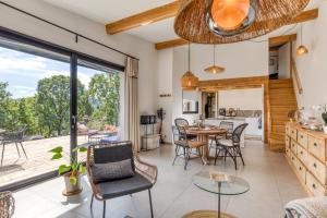 a kitchen and living room with a table and chairs at Le Mas de Coeur in Bédarieux