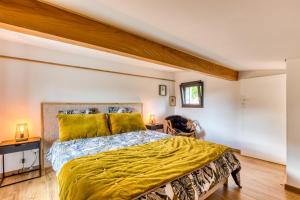 a bedroom with a bed with a yellow bedspread at Le Mas de Coeur in Bédarieux +20 photos