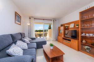 a living room with a blue couch and a television at Apartamento Serendipia in Cala Bona