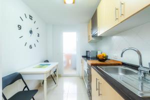 a kitchen with a sink and a clock on the wall at Apartamento Serendipia in Cala Bona