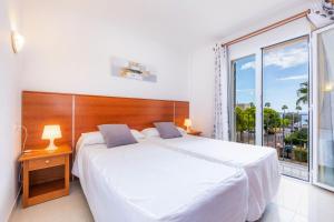a bedroom with a white bed and a large window at Apartamento Serendipia in Cala Bona +16 photos