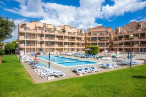 a large hotel with a swimming pool and lounge chairs at Apartamento Serendipia in Cala Bona