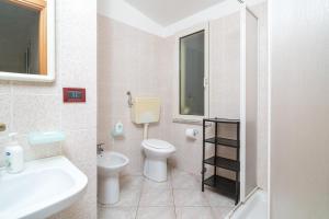 a bathroom with a toilet and a sink at Casa nel centro di Budoni in Budoni +14 photos