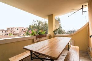 a wooden table on a balcony with a view at Casa nel centro di Budoni in Budoni
