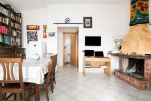 a dining room with a table and a fireplace at Casa nel centro di Budoni in Budoni