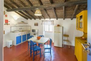a kitchen with a table and some blue chairs at Herdade Vale de Gaios in Odemira