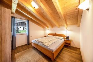 a bedroom with a bed and a wooden ceiling at Panoramawohnung Annaheim in Rifiano