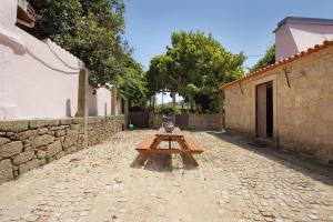 a wooden picnic table sitting on a stone street at Villa Casa do Outeiro in Guilhabreu