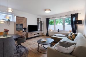 a living room with a couch and a tv at Ferienhaus Anna Elbe in Wischhafen