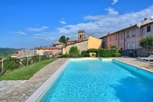 a swimming pool in front of a house with a building at Villa Chelucci - Gualdo in Massarosa