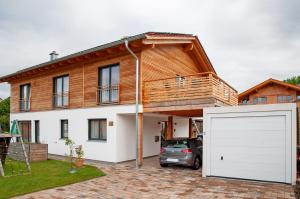 a house with a white garage door in front of it at Ferienwohnung Junge in Halblech