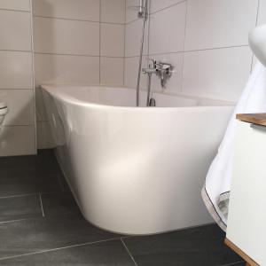 a white bath tub in a white bathroom at Ferienhaus Seltschach 193 in Arnoldstein +35 photos