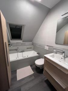 a bathroom with a tub and a toilet and a sink at Pause Tranquille - Chambres d'hôtes in Sablé-sur-Sarthe +19 photos