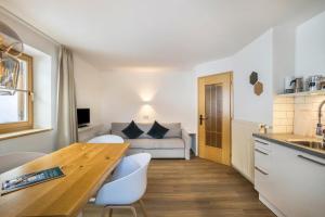 a kitchen and living room with a table and a couch at Mountain Residence Kasern Nr 2 in Predoi