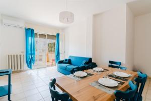 a living room with a dining table and a blue couch at Casa Giselle a Otranto in Otranto