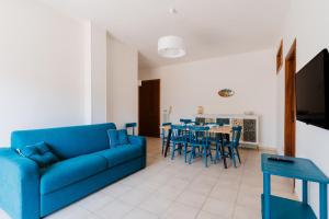 a living room with a blue couch and a table and chairs at Casa Giselle a Otranto in Otranto