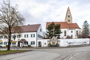 a large white church with a steeple on a street at Leas Ferienwohnung in Aichen