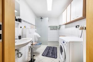 a bathroom with a washing machine and a sink at Leas Ferienwohnung in Aichen +22 photos