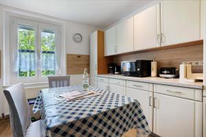 a kitchen with a table with a blue and white checkered table cloth at Gästewohnung am Schwanenteich in Mittweida