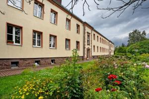 a large building with flowers in front of it at Gästewohnung am Schwanenteich in Mittweida