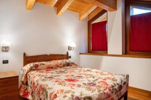 a bedroom with a bed and two windows at Residence Chalet Provenzale in Acceglio
