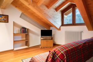 a room with a bed and a tv in a attic at Residence Chalet Provenzale in Acceglio