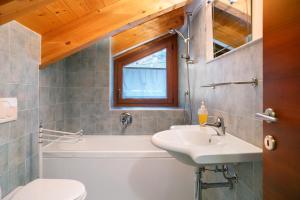 a bathroom with a sink and a tub and a toilet at Residence Chalet Provenzale in Acceglio +7 photos