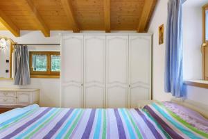 a bedroom with a bed and a white cabinet at Chalet Camillo in Moline