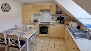 a kitchen with a sink and a table with chairs at Ankerplatz in Lübeck in Lübeck +10 photos