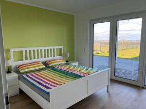 a bedroom with a white bed and a large window at Berg und Meer in WÃ¶lpinghausen