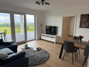 a living room with a couch and a table and a tv at Berg und Meer in WÃ¶lpinghausen