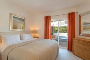 a bedroom with a bed and a sliding glass door at Vila Senna in Vale do Lobo +9 photos
