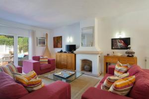 a living room with two red couches and a fireplace at Vila Senna in Vale do Lobo