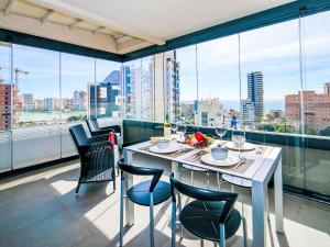 a dining room with a table and chairs and large windows at Apartment Alexia by Interhome in Ifach