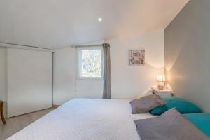 a white bedroom with a bed and a window at La Miellerie in Gréoux-les-Bains +14 photos