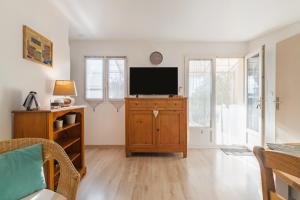 a living room with a television on a wooden cabinet at La Miellerie in Gréoux-les-Bains