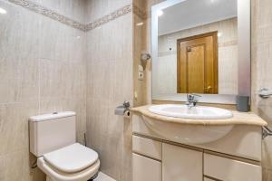a bathroom with a toilet and a sink and a mirror at Sol Mar Arzuaga in Jávea +24 photos