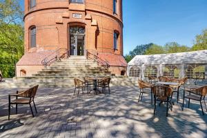 eine Terrasse mit Tischen und Stühlen vor einem Gebäude in der Unterkunft Café Wasserturm Cuxhaven in Cuxhaven