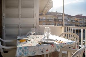 a table with plates and glasses on a balcony at Albenga Le Morelle 2 in Albenga