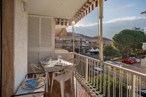 a balcony with a table and chairs and a view of a street at Albenga Le Morelle 2 in Albenga