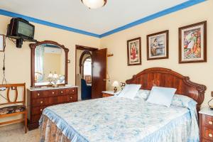 a bedroom with a large bed and a television at Apartamento Oliva in Barbate
