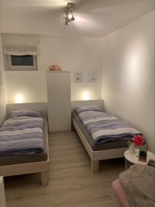 a bedroom with two beds and a table with flowers at Ferienwohnung Am Holing in Bischoffen +17 photos