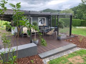 a tiny house with a deck with a table at Ferienwohnung Am Holing in Bischoffen